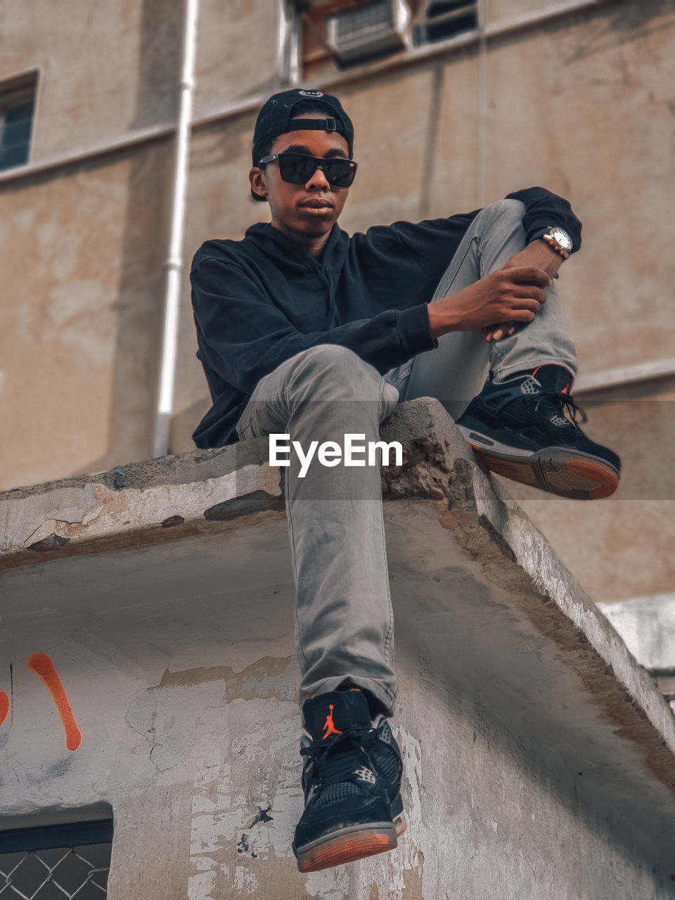 YOUNG MAN WEARING SUNGLASSES OUTDOORS