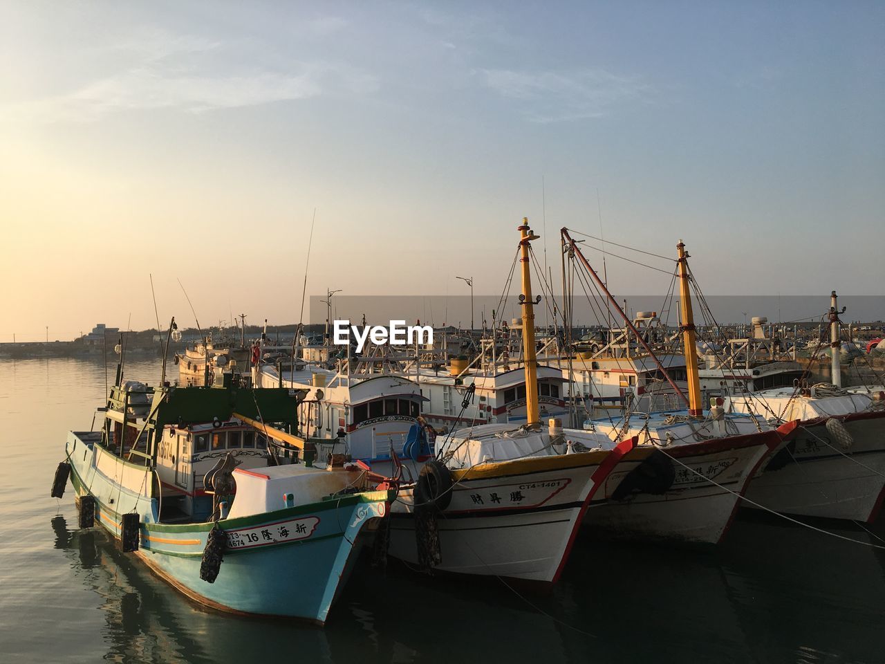 Boats moored at harbor against sky