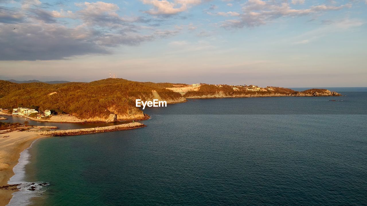 water, sea, sky, land, coast, body of water, scenics - nature, beauty in nature, shore, beach, nature, horizon, cloud, travel destinations, ocean, landscape, environment, coastline, travel, tranquility, cliff, bay, terrain, tranquil scene, no people, dusk, sunset, architecture, outdoors, rock, tourism, idyllic, mountain, seascape, holiday, island, blue, vacation, trip, non-urban scene, day, high angle view, reflection