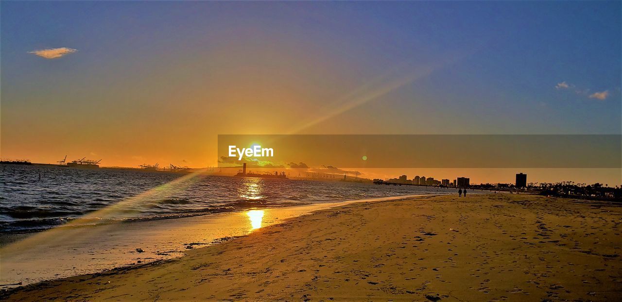 SCENIC VIEW OF BEACH AGAINST SKY AT SUNSET