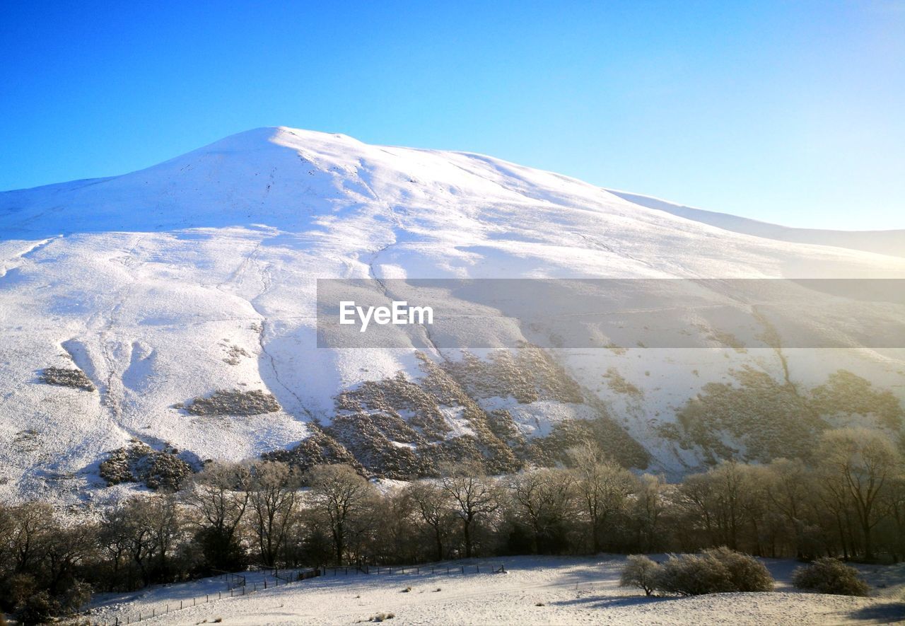 Scenic view of snowcapped mountains against clear sky