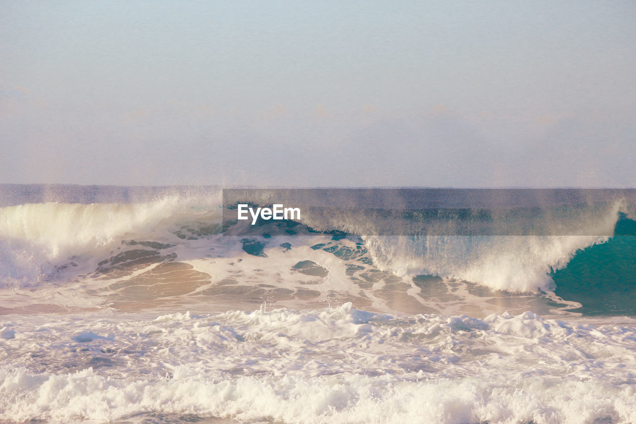 Big ocean waves crushing on a sandy beach