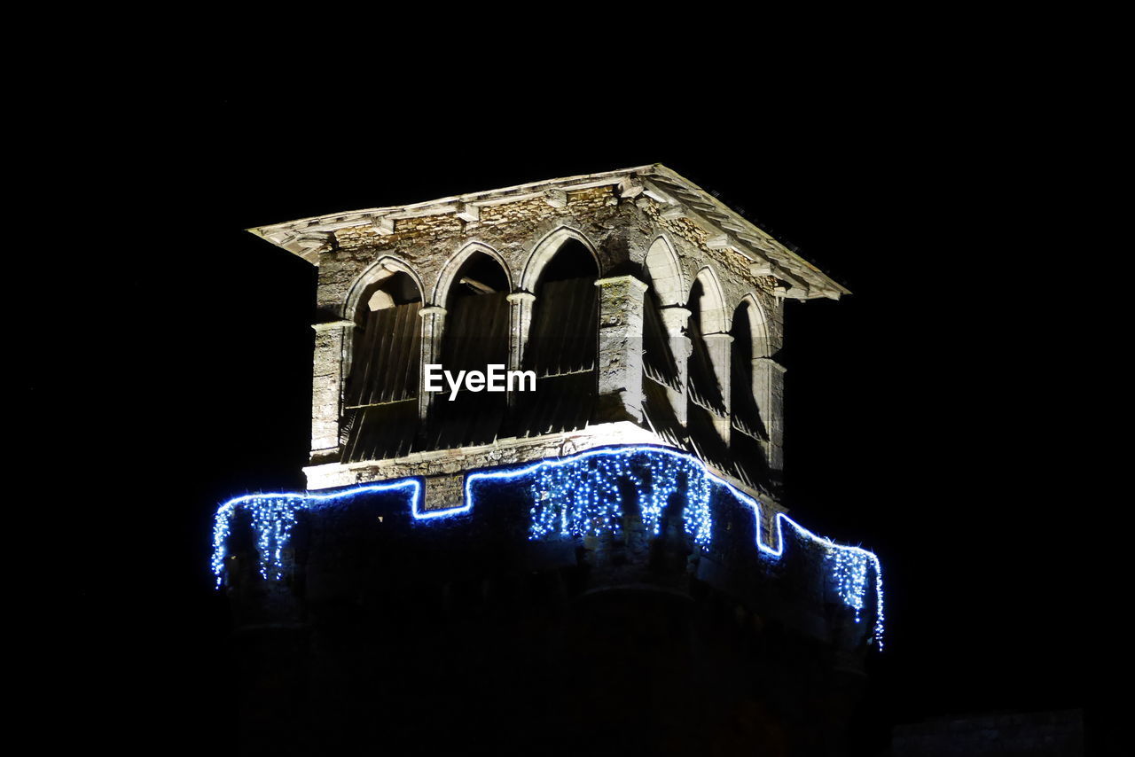 LOW ANGLE VIEW OF ILLUMINATED TEMPLE AGAINST SKY