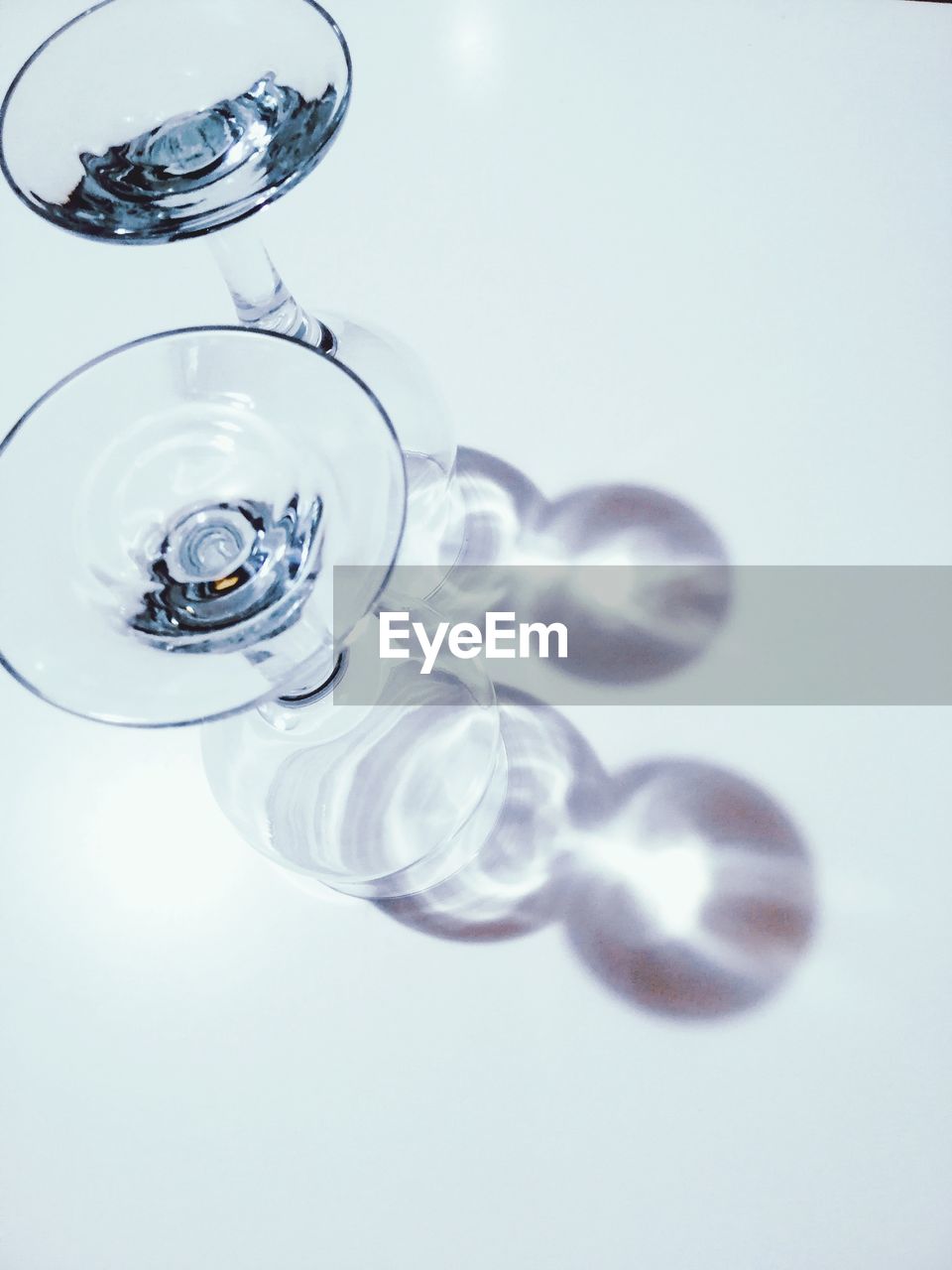 HIGH ANGLE VIEW OF DRINKING GLASS ON WHITE TABLE