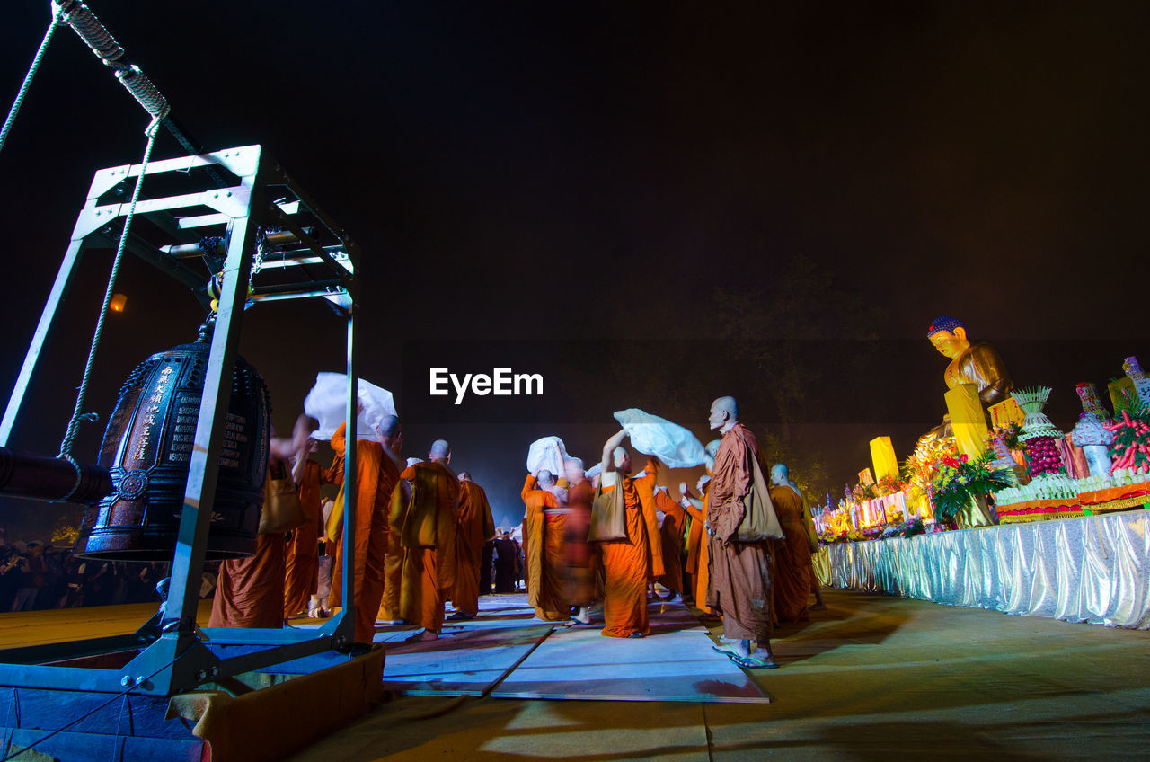 PANORAMIC VIEW OF PEOPLE AT ILLUMINATED TEMPLE