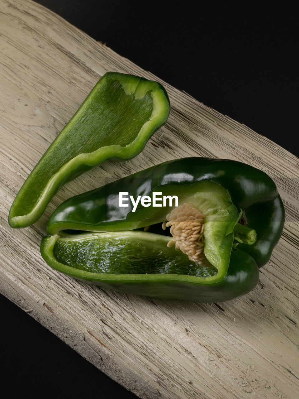 High angle view of green bell pepper on wood