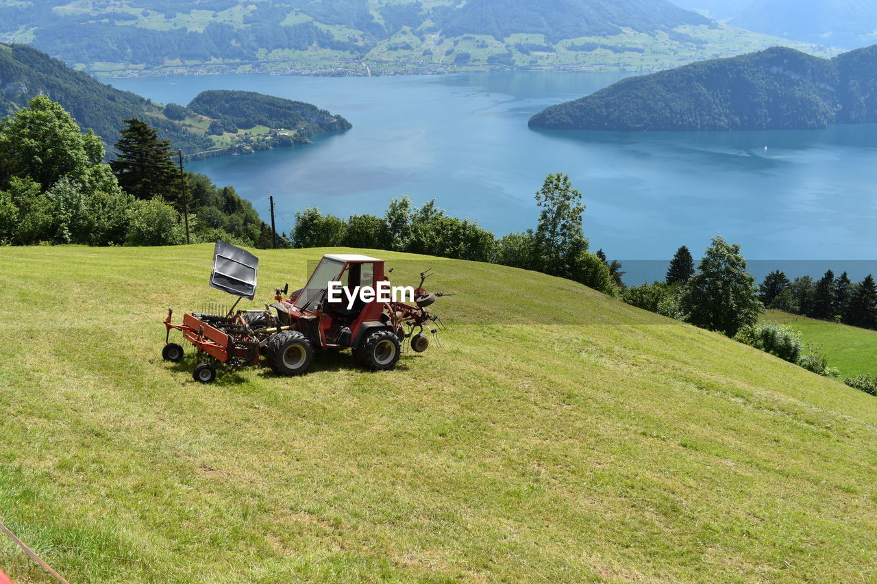 Tractor on field against mountains