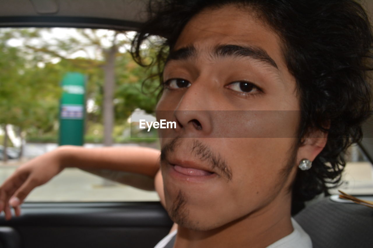 Portrait of young man in car