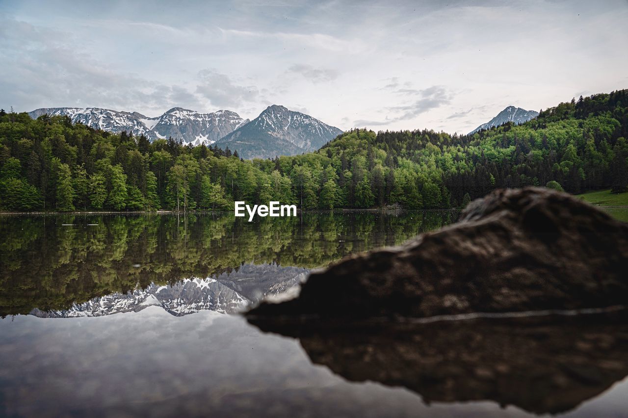 Scenic view of lake by mountains against sky