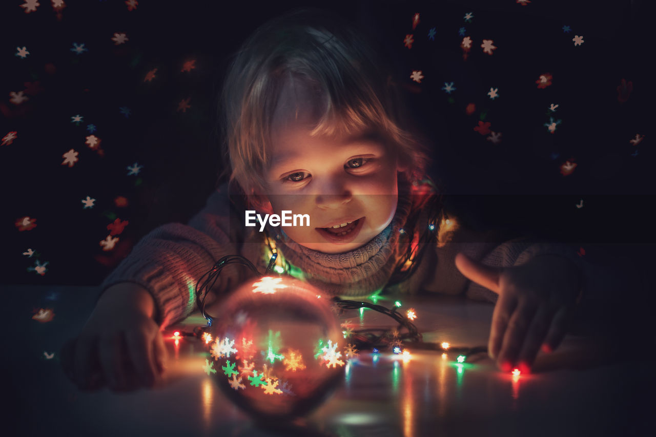 Portrait of child looking at illuminated christmas lights