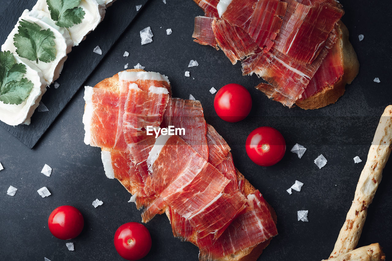 Ham still life cut with bread, oil and tomato. concept of gastronomy