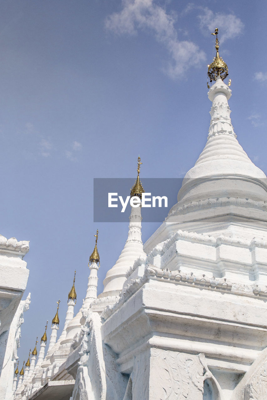 White small stupas at sanda muni pagoda under blue sky, mandalay