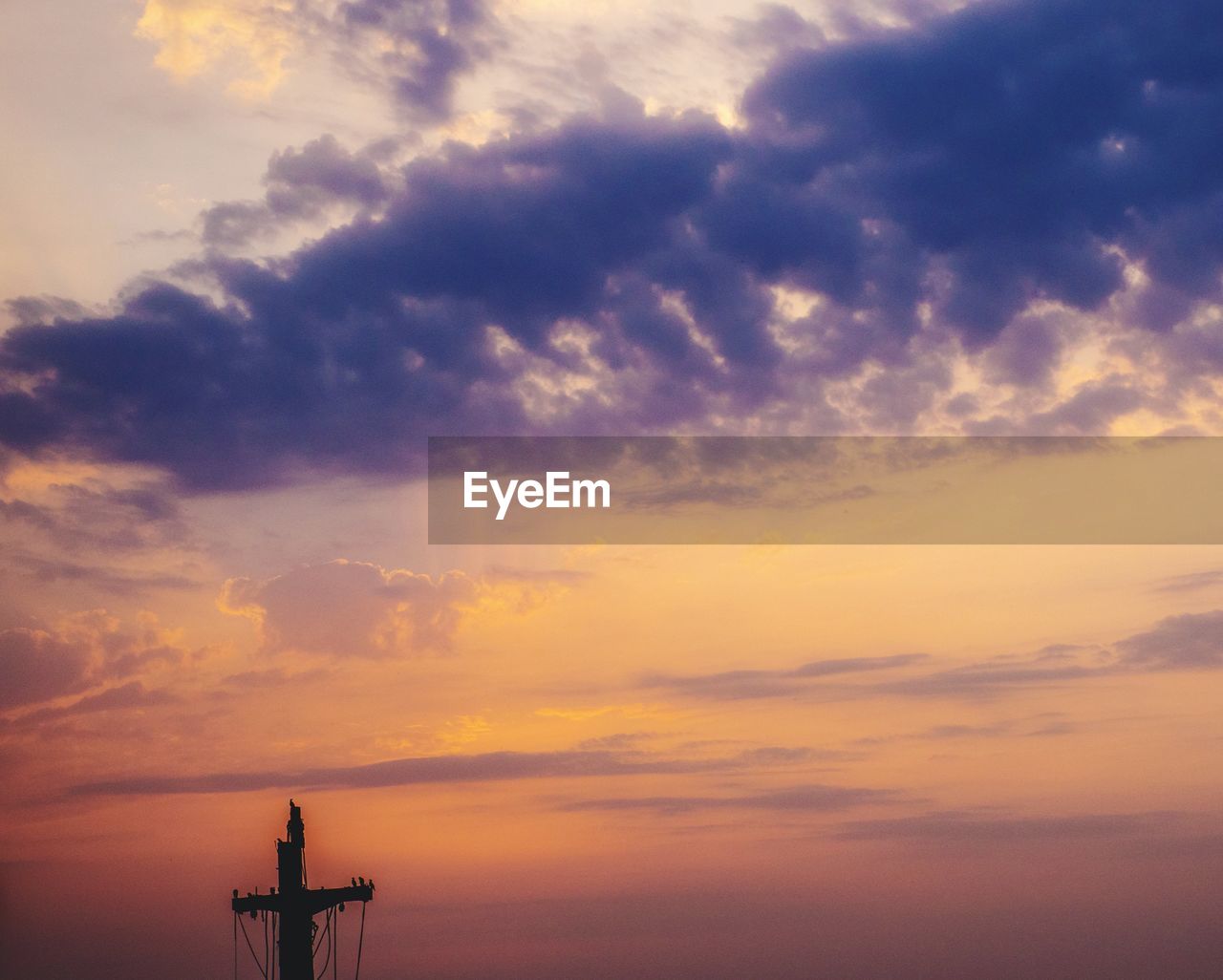 SILHOUETTE OF COMMUNICATIONS TOWER AT SUNSET