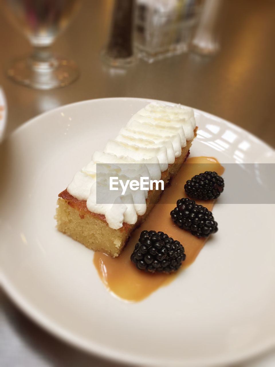 High angle view of hazelnut cake with blackberries served in plate on table