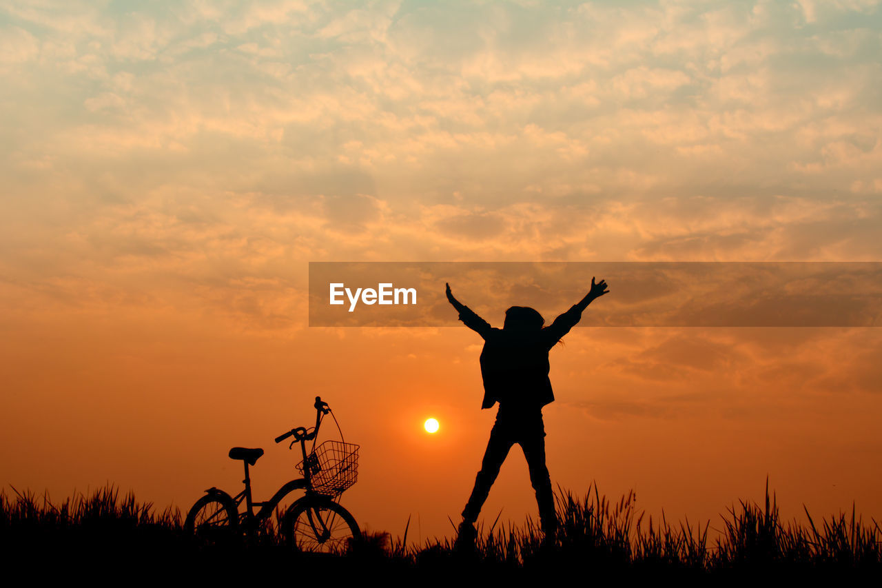 Silhouette of person jumping against sunset