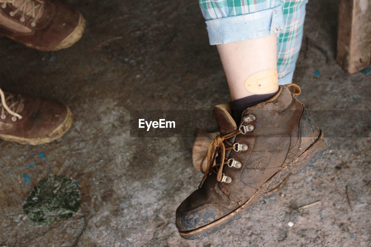 CLOSE-UP LOW SECTION OF WOMAN STANDING ON FLOOR