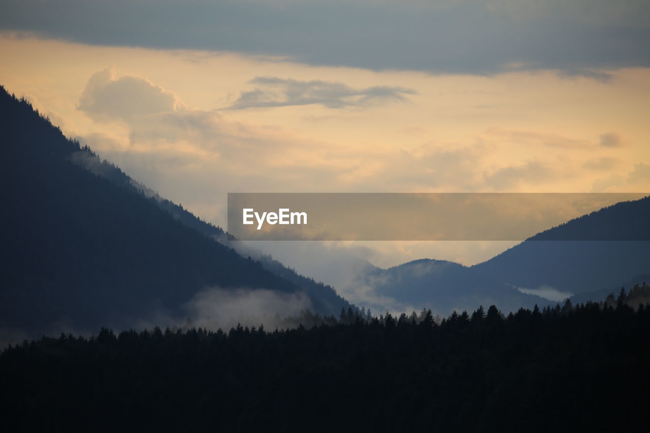 Scenic view of silhouette mountains against sky at sunset