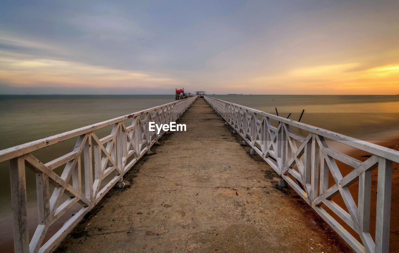 PIER LEADING TOWARDS SEA AGAINST SKY DURING SUNSET