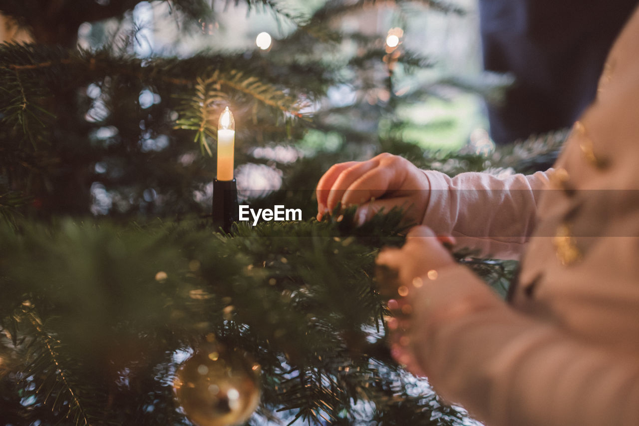 Close-up of girl decorating christmas tree