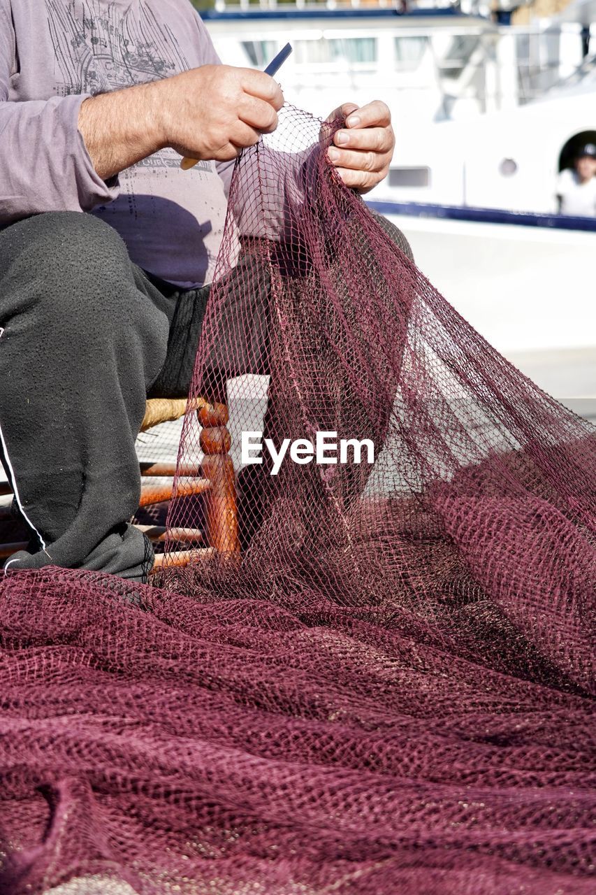 Midsection of man holding fishing net