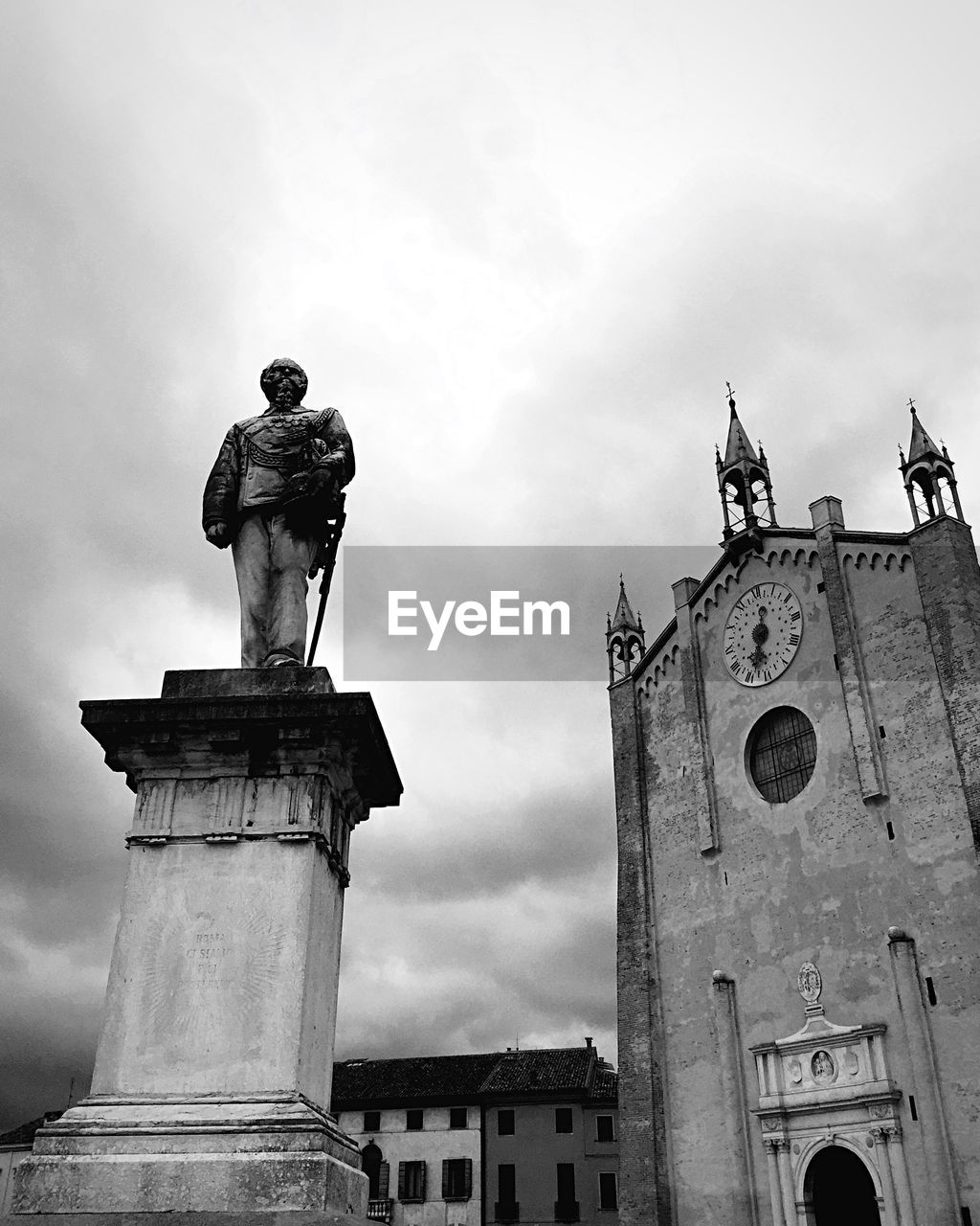 Low angle view of church with statue against sky