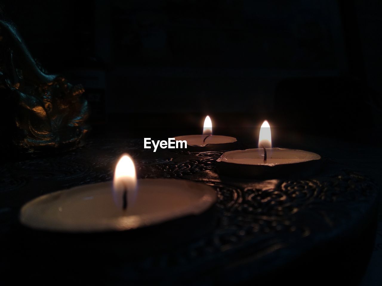 Close-up of lit tea light candles in temple