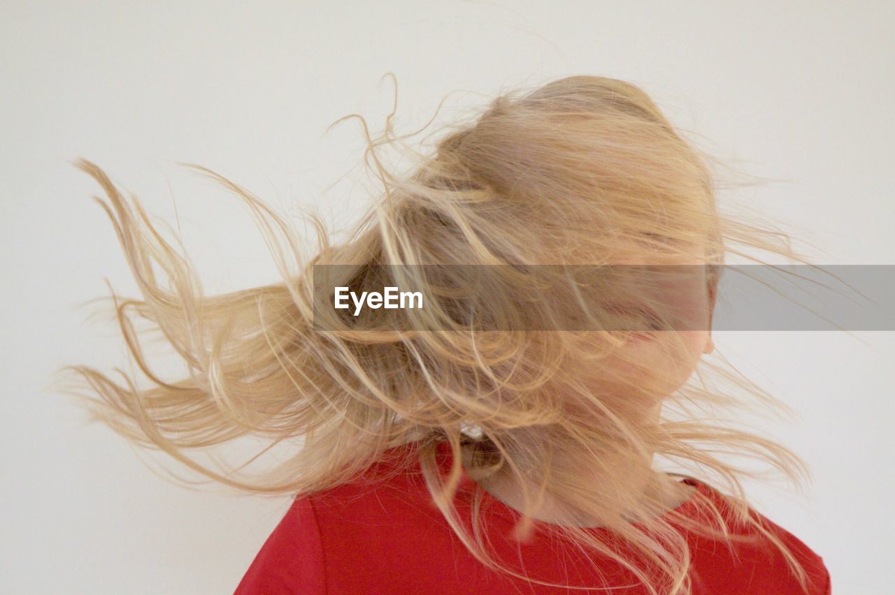 Blond woman with tousled hair against white background