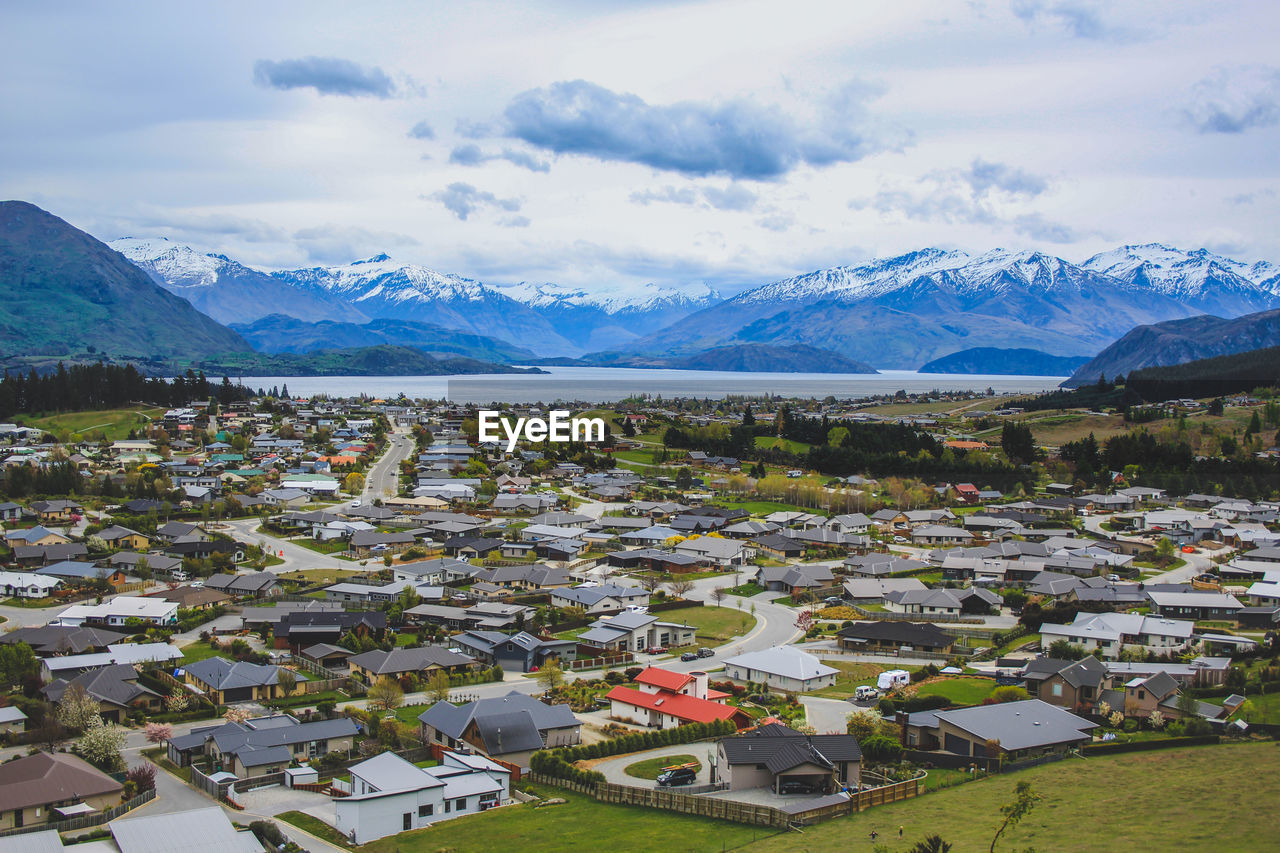 Scenic view of townscape and mountains against sky