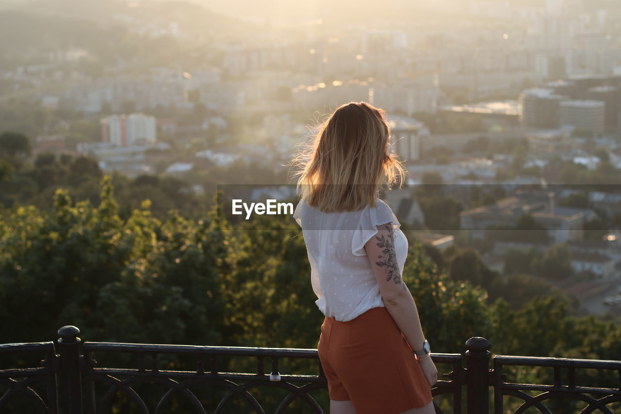 Rear view of woman looking at cityscape