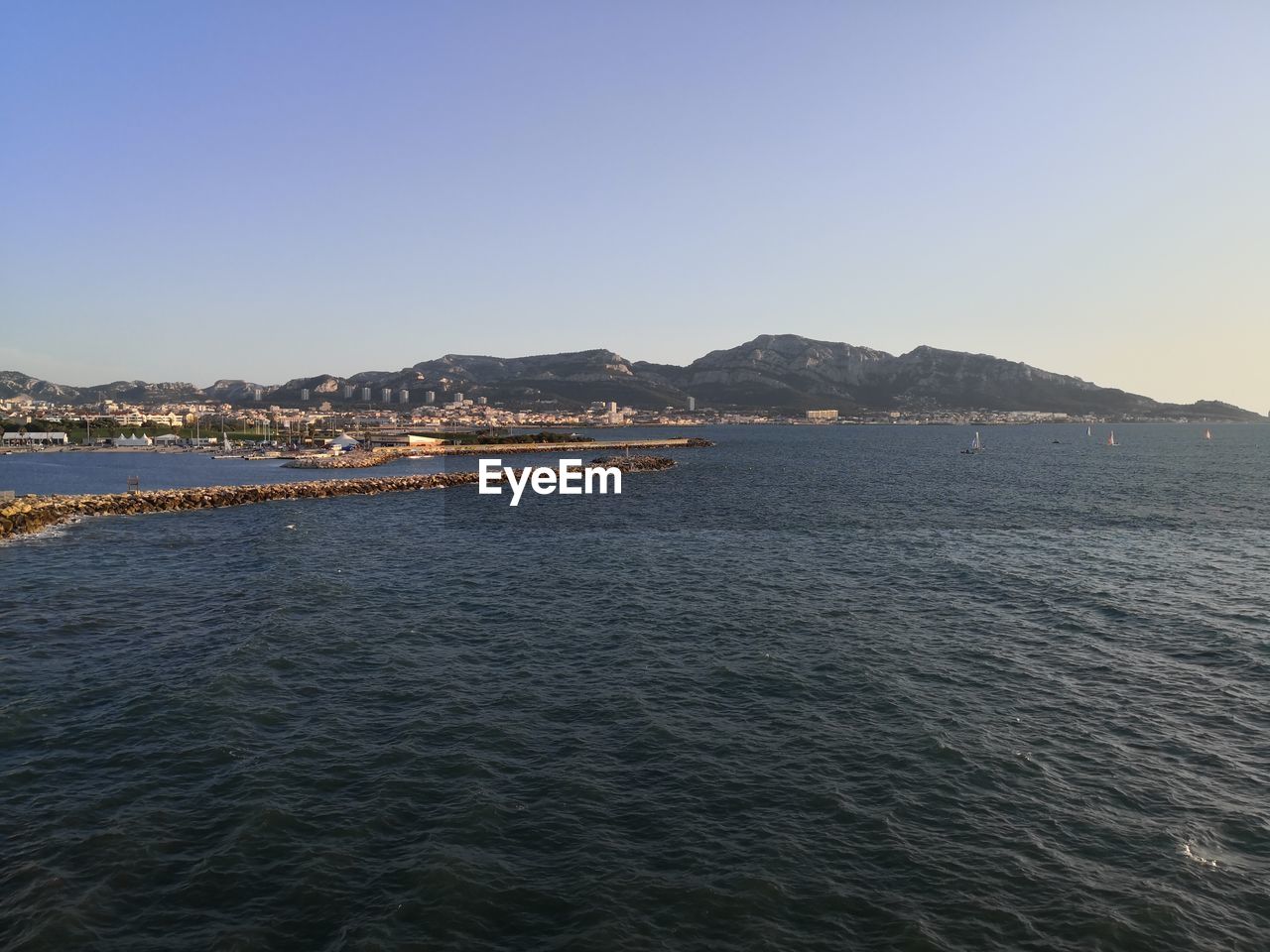 SCENIC VIEW OF SEA AND MOUNTAINS AGAINST CLEAR SKY