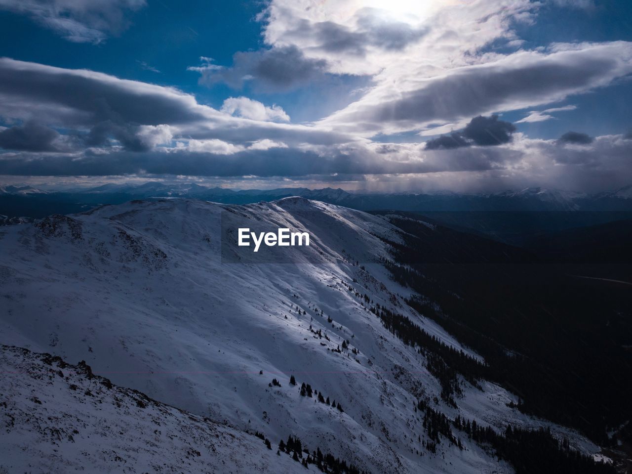 AERIAL VIEW OF SNOWCAPPED MOUNTAINS AGAINST SKY