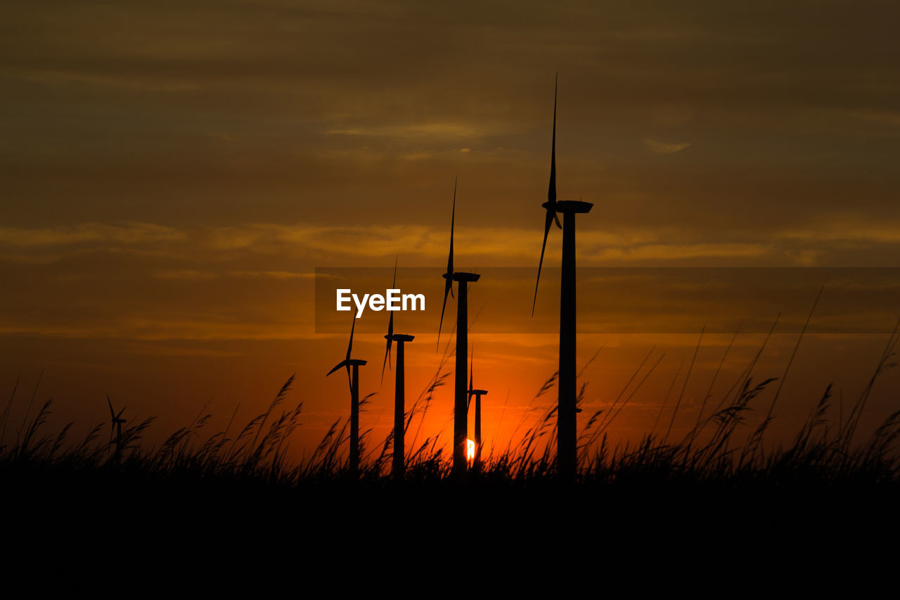 SILHOUETTE WINDMILL ON FIELD AGAINST SKY DURING SUNSET