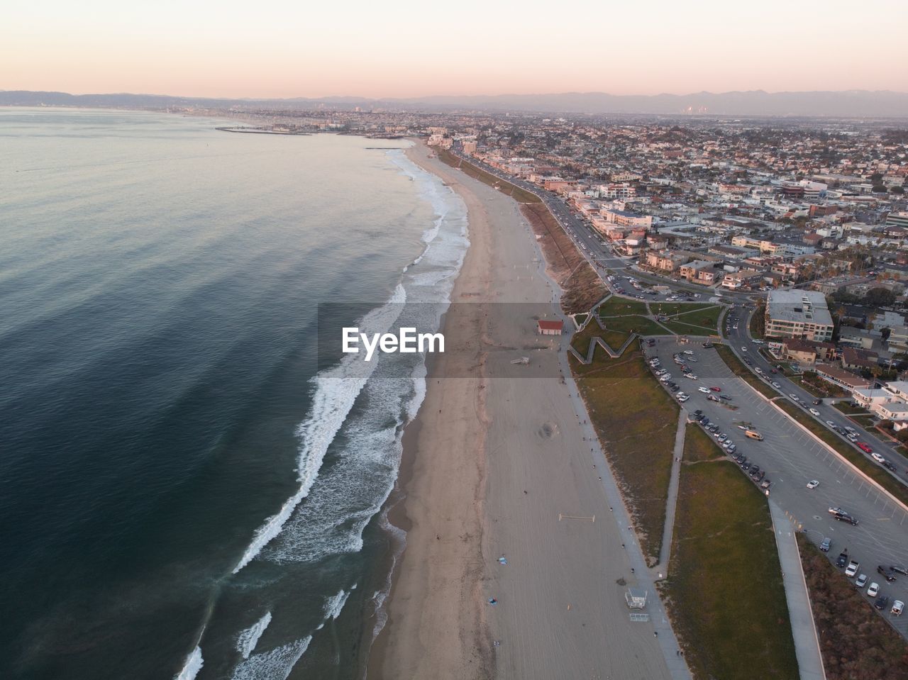 High angle view of sea and buildings against sky during sunset