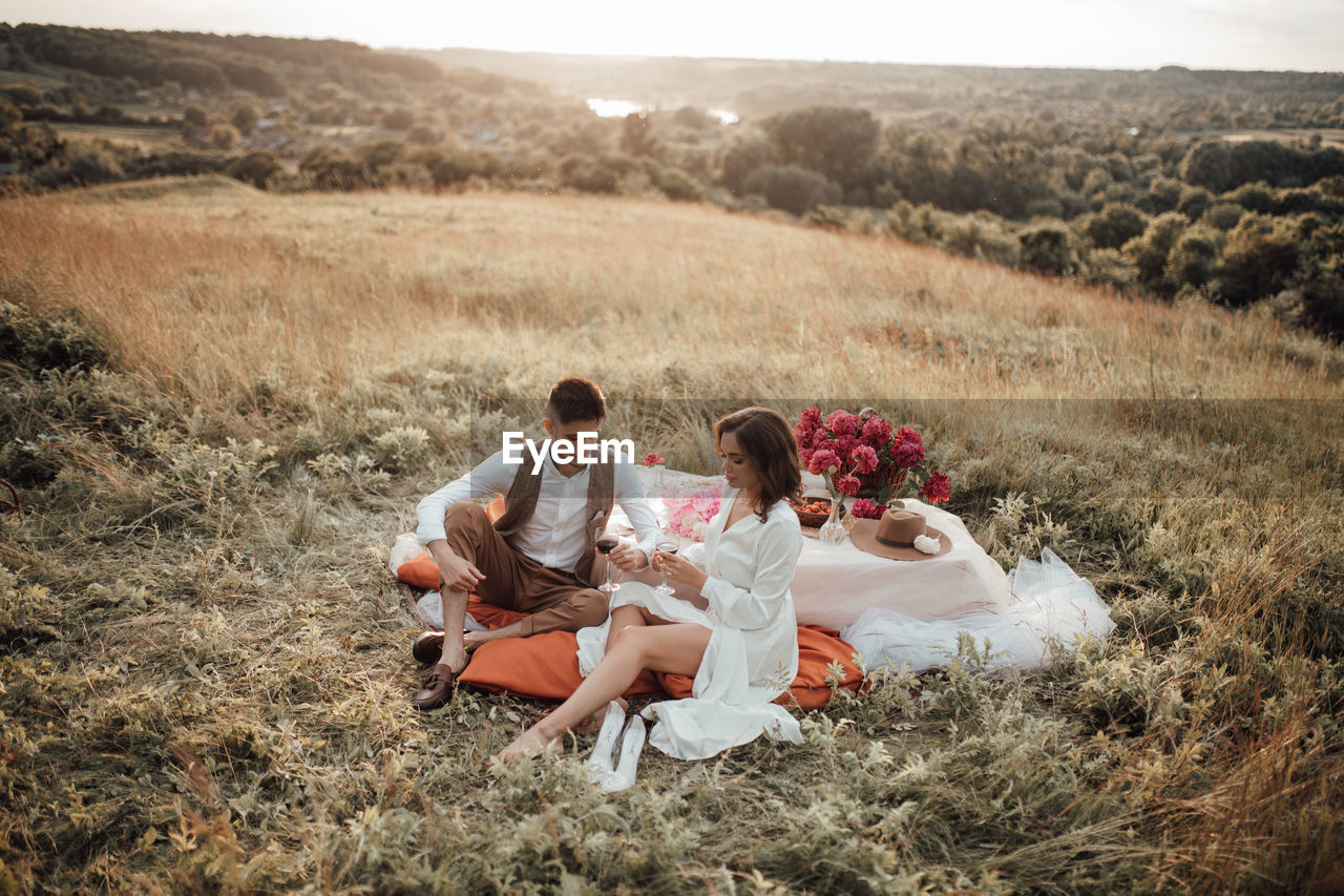 Couple sitting on land by plants