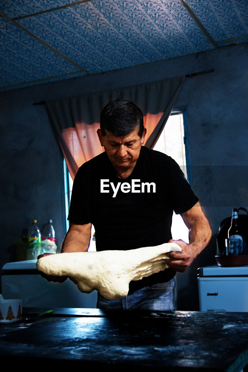 Portrait of man preparing dough for bread