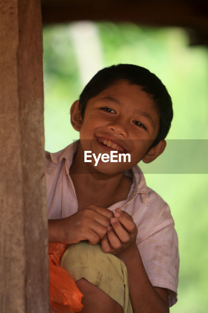 Close-up of smiling boy looking away