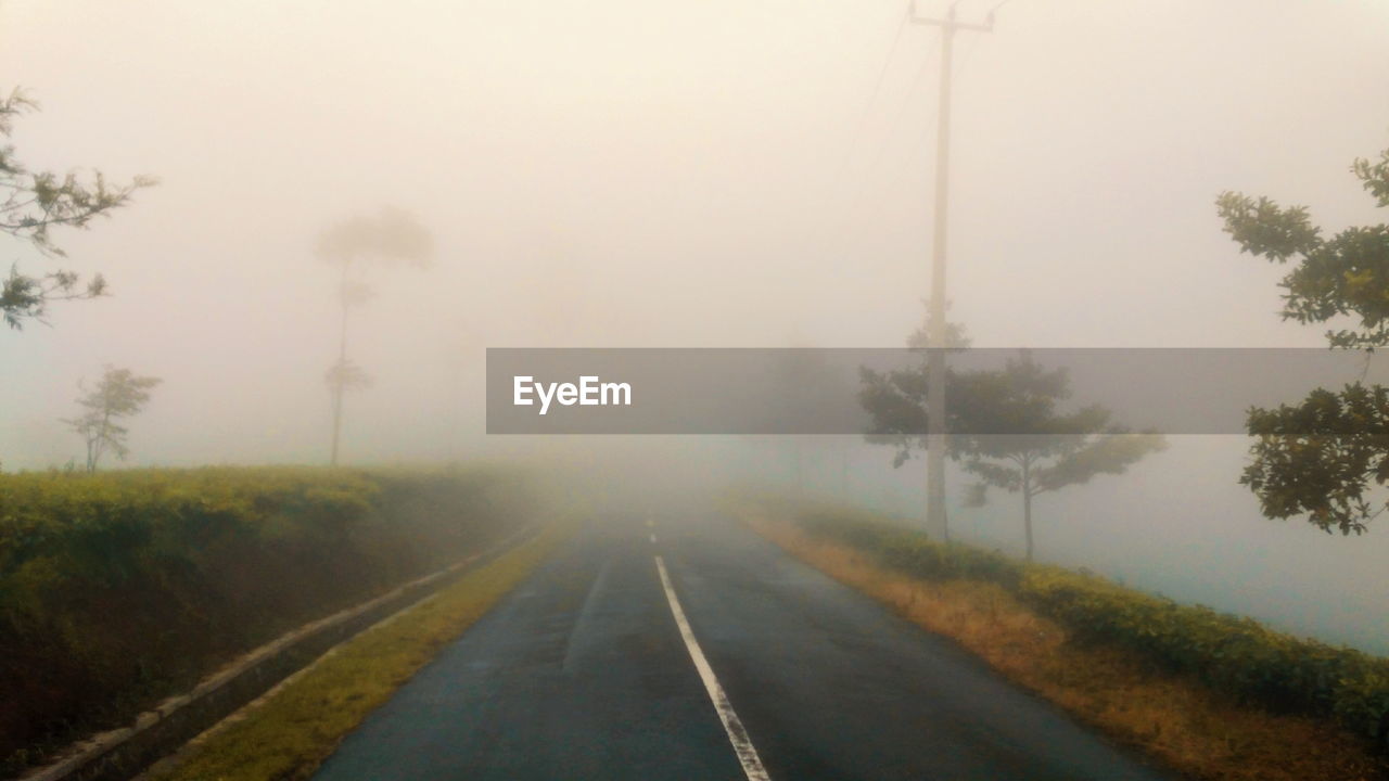 ROAD IN FOGGY WEATHER AGAINST SKY