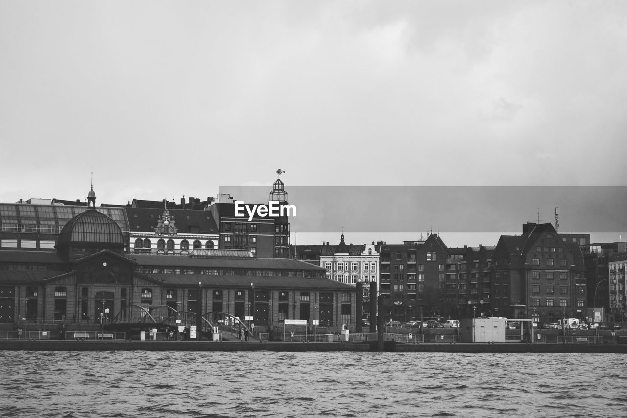 Buildings in city against cloudy sky