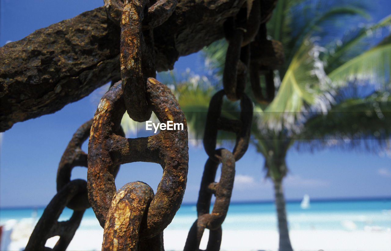 Close-up of rusty metallic chain at beach