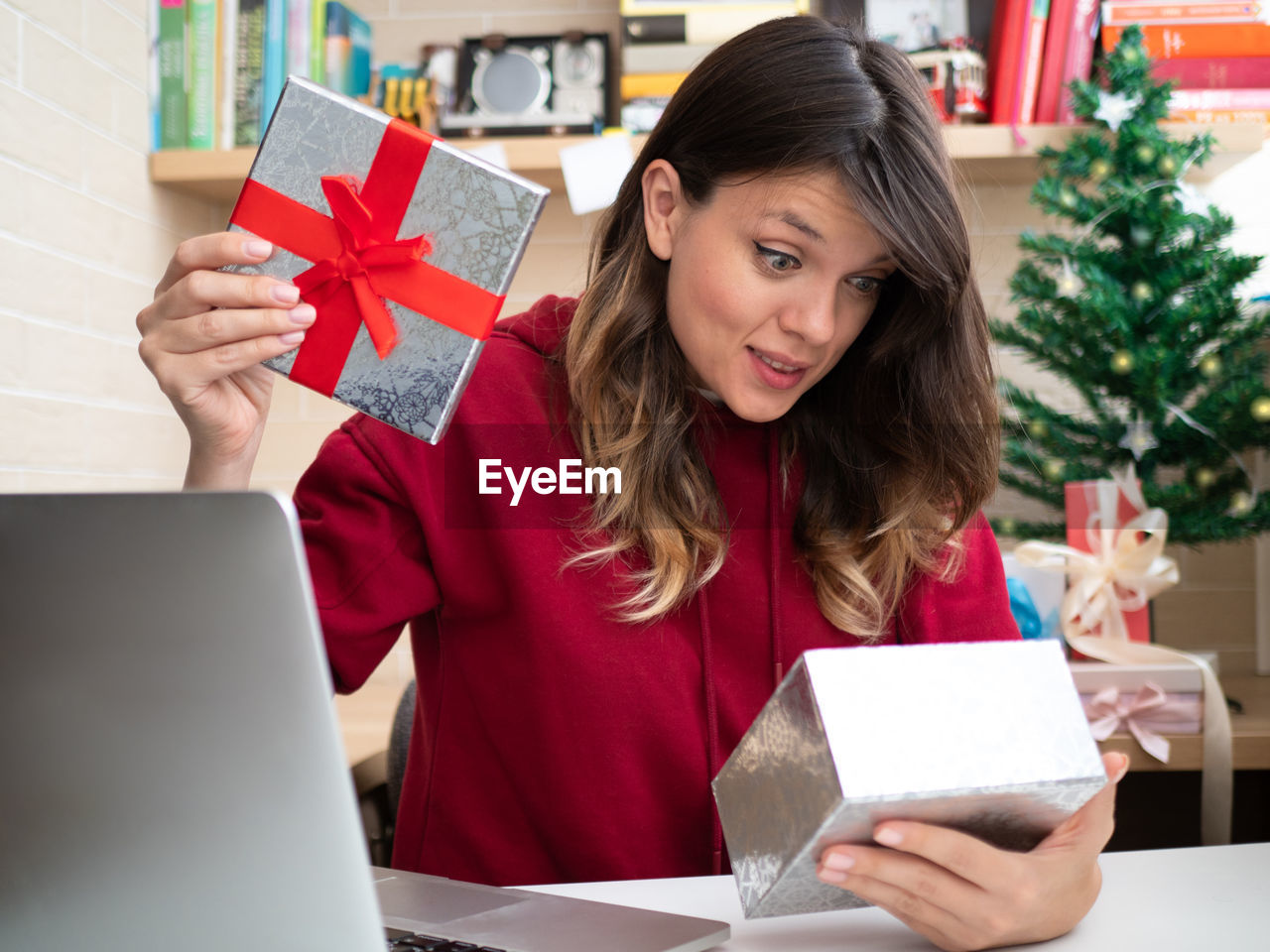 MID ADULT WOMAN HOLDING PAPER WITH CHRISTMAS LIGHTS