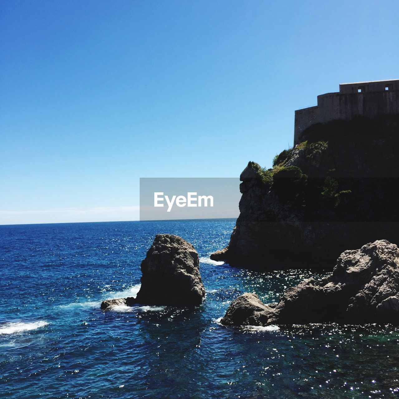 View of building on cliff and sea