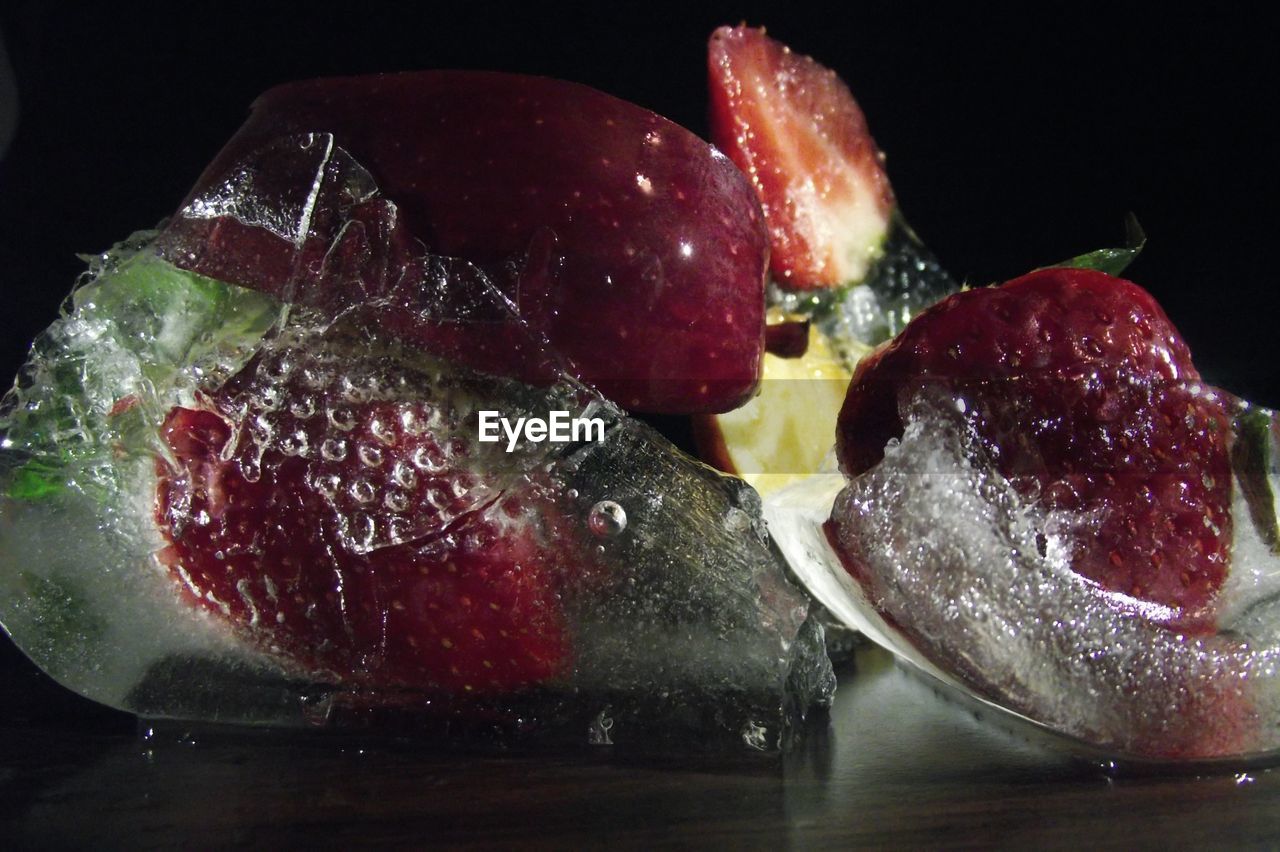 Close-up of fruits on table against black background