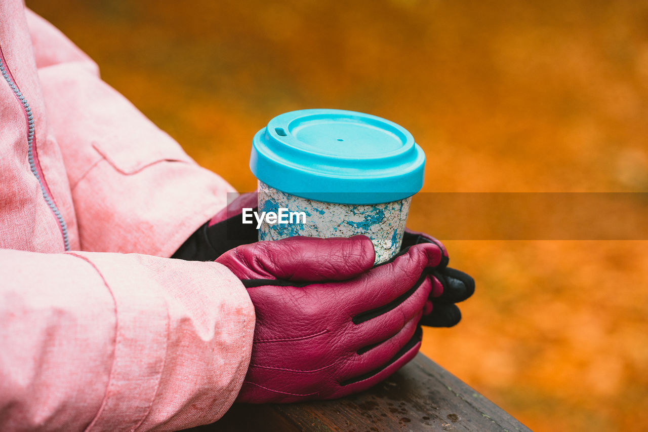 Close-up of woman holding coffee cup outdoors during winter