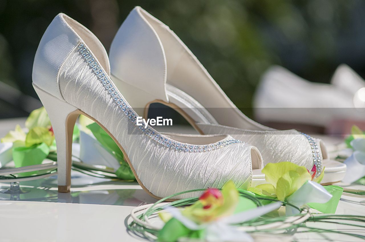 Close-up of stilettoes amidst artificial flower decoration on car roof