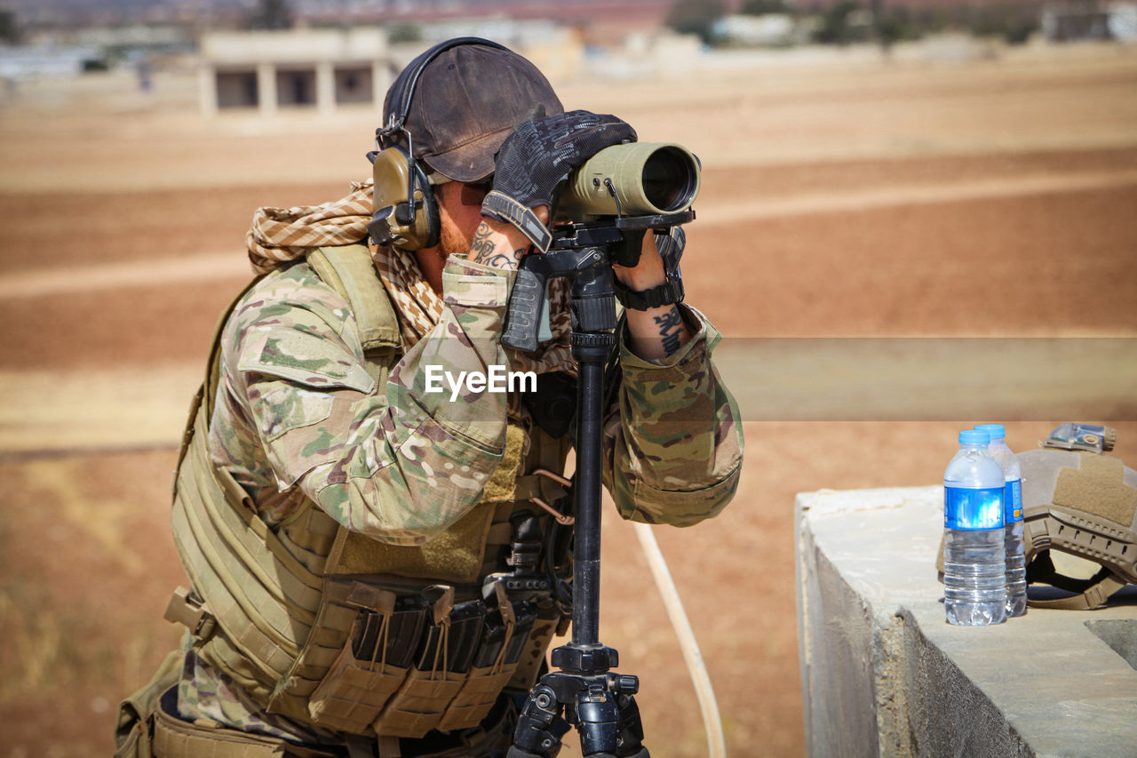 Army soldier looking through binoculars