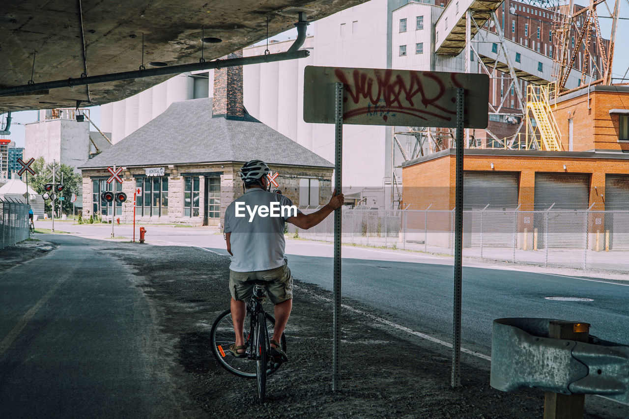 Rear view of man riding bicycle on street