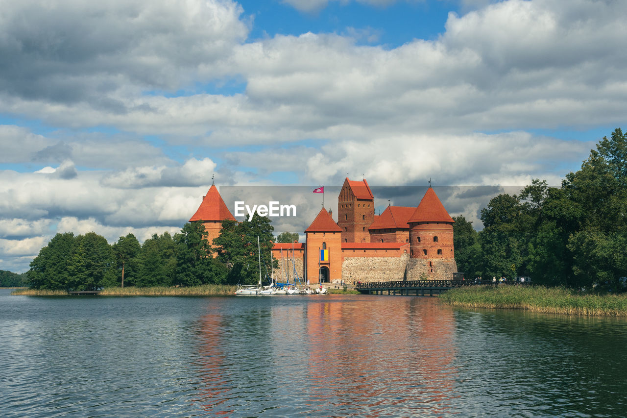 architecture, water, built structure, cloud, sky, building exterior, building, travel destinations, nature, reflection, river, history, tree, the past, religion, place of worship, travel, plant, no people, tourism, château, city, vacation, belief, landscape, outdoors, water castle, house, day, waterfront, waterway, blue, environment