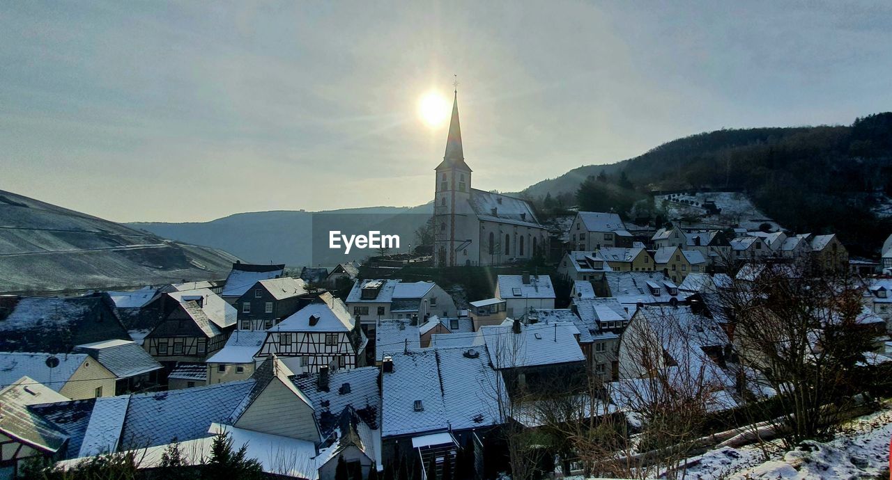 Buildings in town against sky during winter