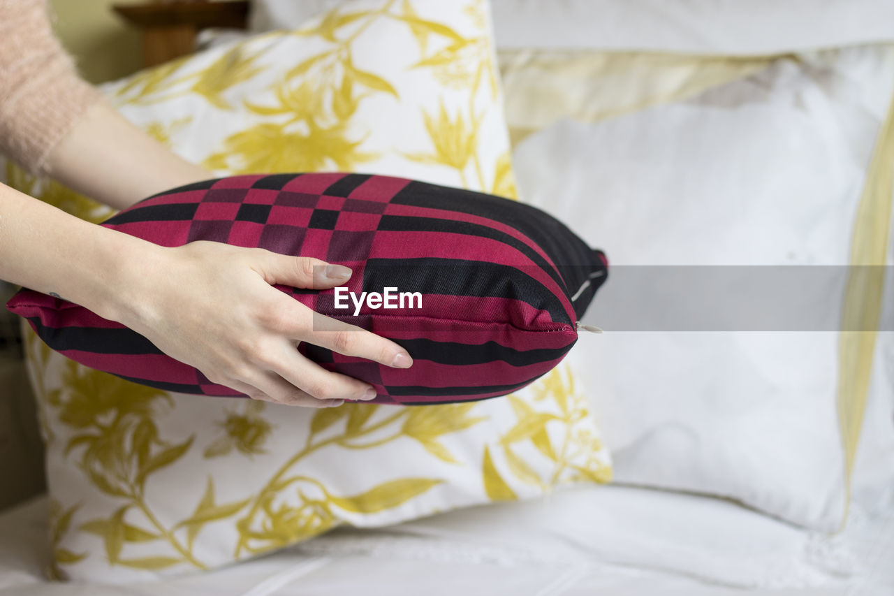Close-up of woman holding pillow on bed