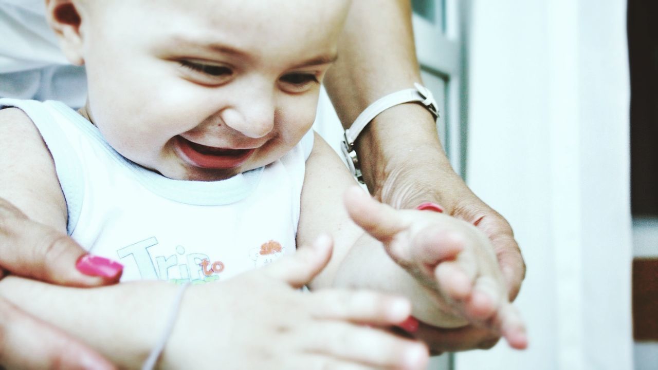 Cute happy baby with mother holding hands